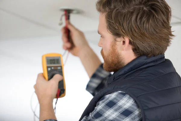 Elettricista Misura Della Tensione Dal Filo Sul Soffitto — Foto Stock