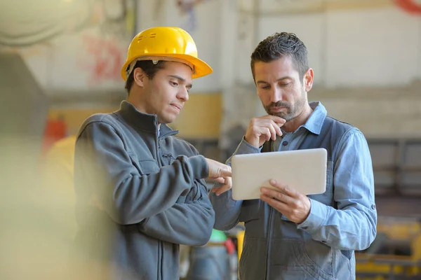 Trabalhadores Manuais Contemplativos Olhando Para Tablet Digital — Fotografia de Stock