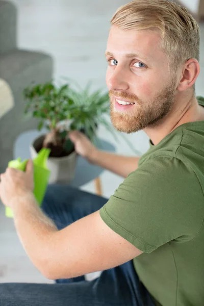 Atrakcyjny Młody Człowiek Mieszkaniu Podlewania Roślin — Zdjęcie stockowe