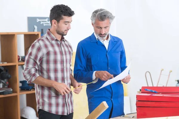 Tischler Zeigt Mitarbeitern Etwas — Stockfoto