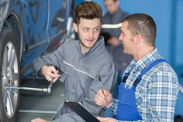 Closeup Two Men Working Wheel Garage — Zdjęcie stockowe