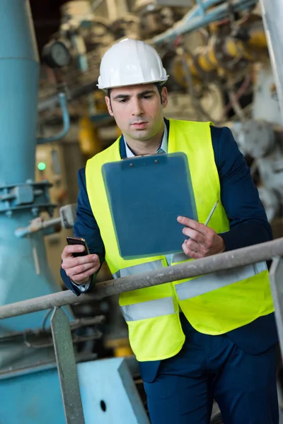 Suited Man Site Holding Clipboard Smartphone — ストック写真