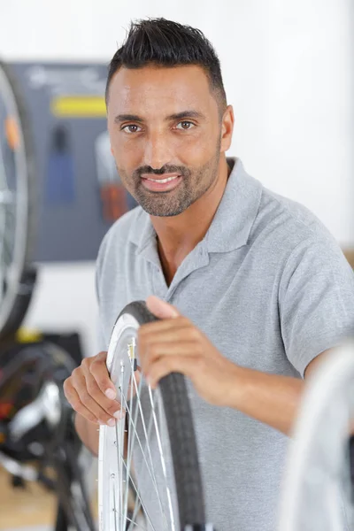 Glad Seller Repairing Bike Wheel — Stockfoto