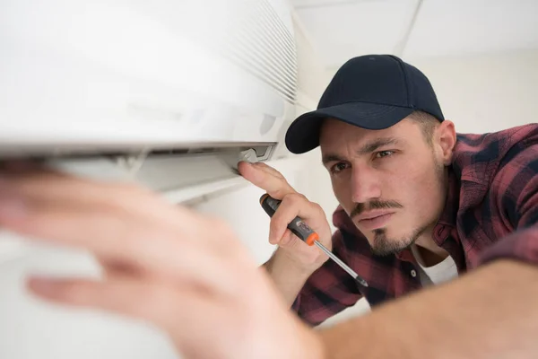 Männlicher Arbeiter Überprüft Den Zustand Einer Klimaanlage — Stockfoto