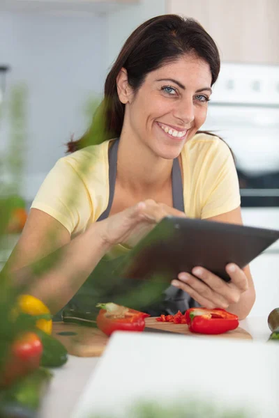 Woman Using Tablet Computer While Cooking Her Kitchen — Stok fotoğraf