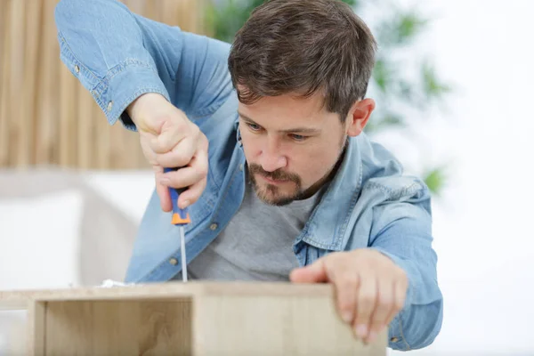 Homme Visse Les Jambes Une Table Bois — Photo