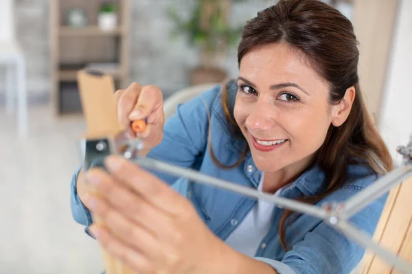 Confident Woman Assembling Furniture Screwdriver — 图库照片