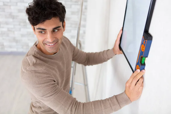 Young Man Installs Whiteboard Spirit Level — Stock Photo, Image