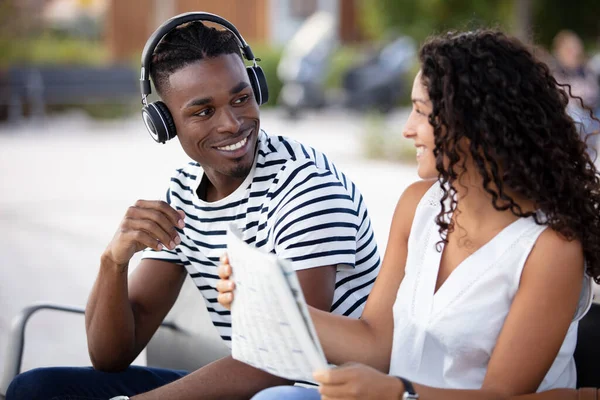 Multiracial Couple Sit Bench Man Wears Headphones — 图库照片