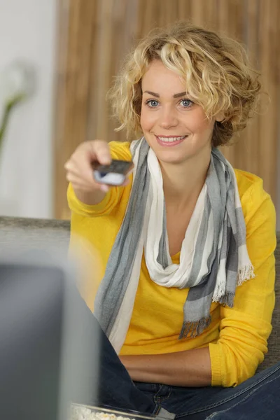 Frau Wechselt Fernsehkanäle Mit Fernbedienung — Stockfoto