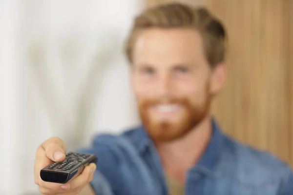 Afstandsbediening Gehouden Door Wazig Jongeman Achtergrond — Stockfoto