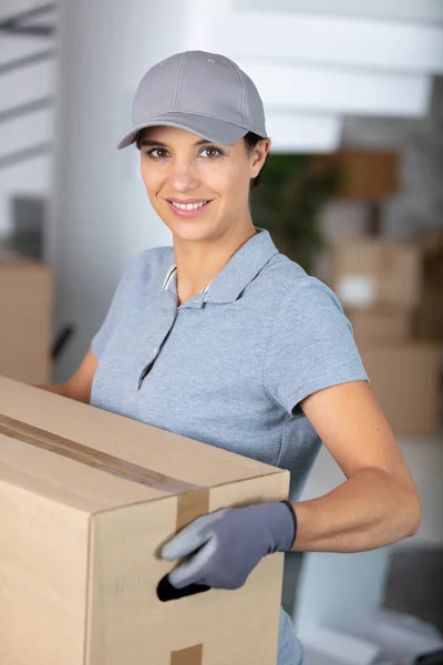 Zustellerin Hält Paket Der Hand Und Lächelt — Stockfoto