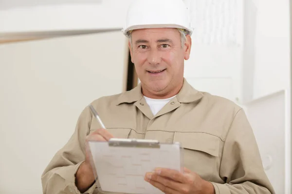 Männlicher Bauarbeiter Mit Klemmbrett Blickt Die Kamera — Stockfoto