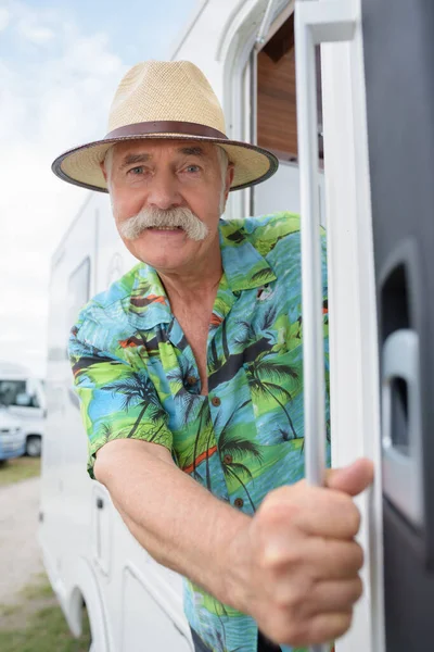 ヴィンテージ キャンピングカーに乗る年配の男性 — ストック写真