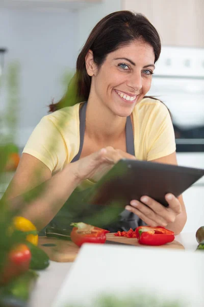 Woman Using Tablet Computer While Cooking Her Kitchen — Stock Photo, Image