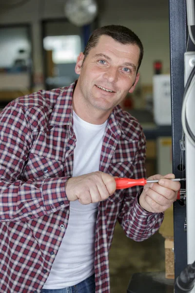 Ein Mann Schraubt Einer Maschine — Stockfoto