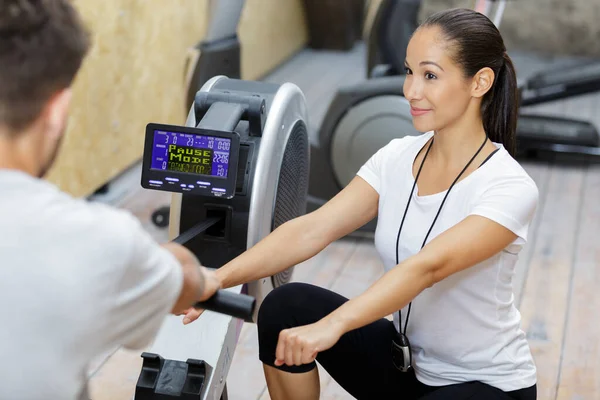 Man Exercising Using Rowing Machine Coached Trainer — Stock Photo, Image