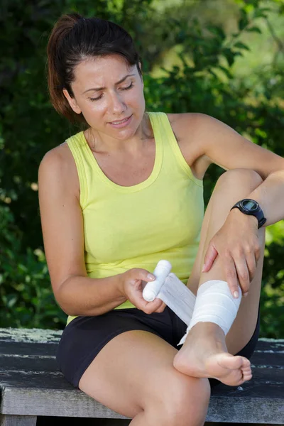 若い女性ランナーが屋外で痛みに足を触れ — ストック写真