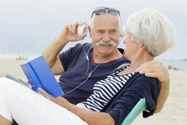 Seniorenpaar Steht Strand Und Hört Mp3 Player — Stockfoto