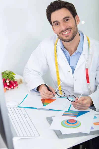 Nutricionista Masculino Sentado Escritorio Cubierto Con Gráficos — Foto de Stock