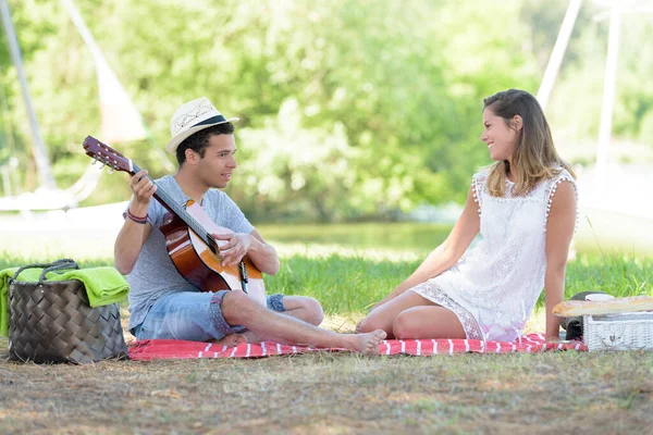 公園でギターを楽しんでいる若いカップルは — ストック写真