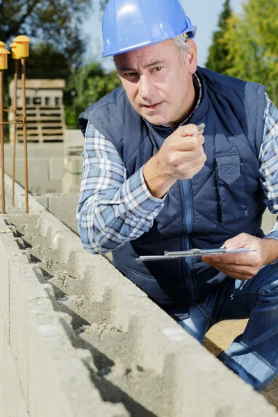 Beton Duvarı Kontrol Eden Bir Inşaatçı — Stok fotoğraf