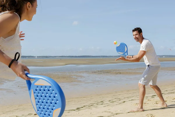 若いカップルがビーチテニスをしていて — ストック写真