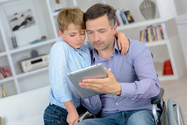 Mann Rollstuhl Wird Mit Tablet Von Kind Umarmt — Stockfoto