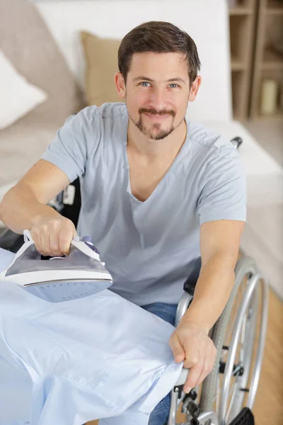 Χαρούμενος Ανάπηρος Άνθρωπος Αναπηρική Καρέκλα Σιδέρωμα Ρούχα — Φωτογραφία Αρχείου