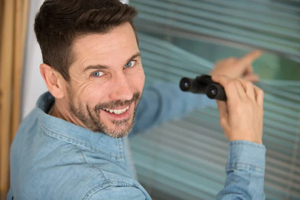 Uomo Sorridente Piedi Vicino Alla Finestra Con Binocolo — Foto Stock