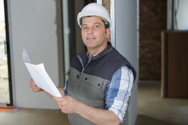 portrait of construction worker holding paper of drawing