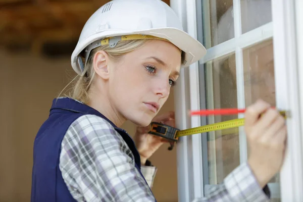 Ett Mätfönster För Kvinnliga Byggare — Stockfoto