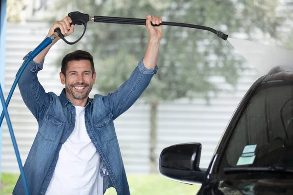 Homem Feliz Lavando Seu Carro Com Mangueira Alta Pressão — Fotografia de Stock