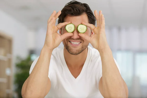 Homem Segurando Fatias Pepino Fresco Seu Rosto — Fotografia de Stock