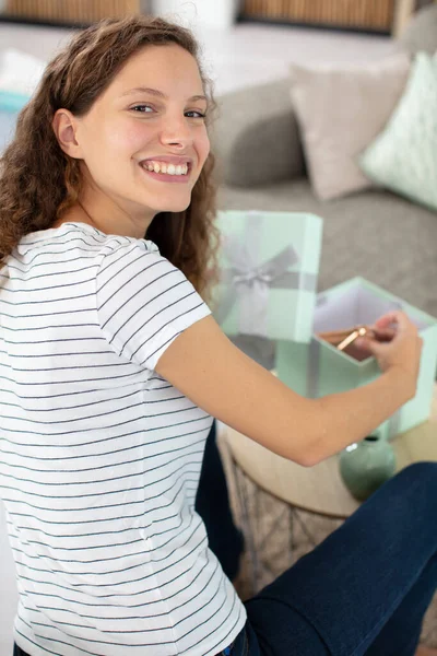 Woman Opening Gift Box Looking Back Her Shoulder — Stock Photo, Image