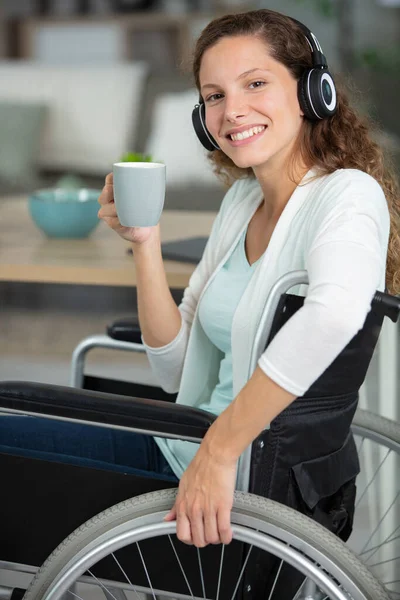 Vrouw Rolstoel Draagt Een Koptelefoon Houdt Een Koffie — Stockfoto