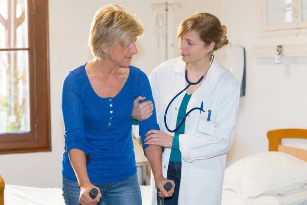 Nurse Helping Senior Woman Getting Bed — Stock Photo, Image