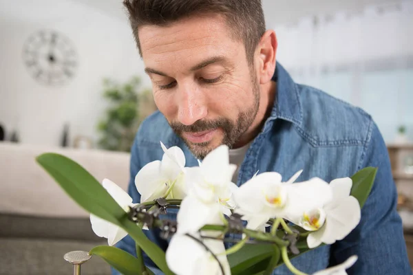 Чоловік Вдома Насолоджується Ароматом Його Квітів — стокове фото