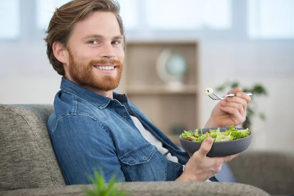 Jeune Homme Sur Canapé Manger Une Salade — Photo