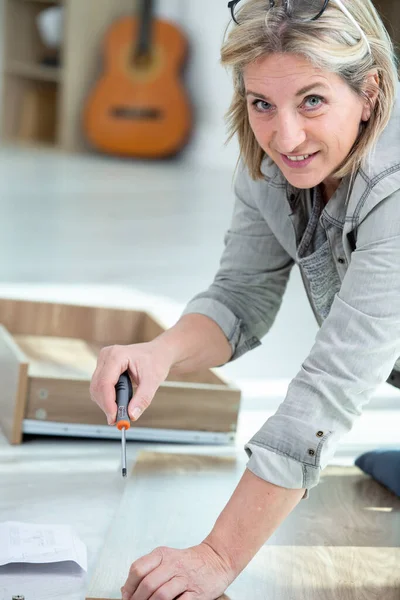 Mature Woman Assembling Furniture New Home — Stock Photo, Image