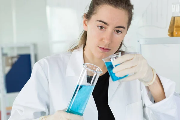 Chimiste Femme Regarde Verre Dans Laboratoire — Photo