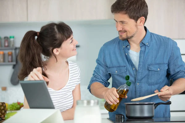 一对快乐的年轻夫妇在厨房里一起做饭的肖像 — 图库照片