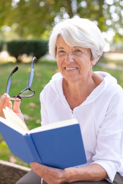 Starší Žena Čtení Knih Položen Trávě — Stock fotografie