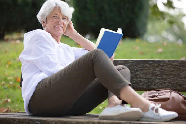 Donna Pensione Che Legge Libro Sulla Panchina — Foto Stock