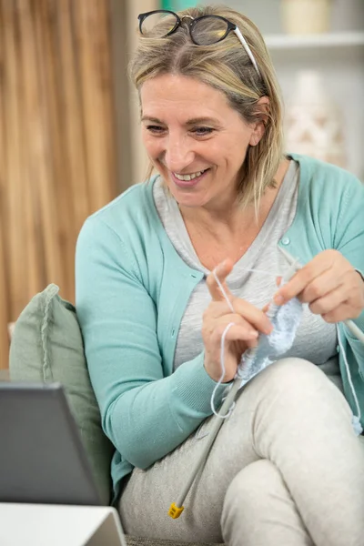 Vrouw Breien Deken Ontspannen Kijken Iets Haar Tablet — Stockfoto