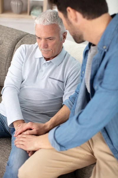 Jeune Homme Assis Sur Canapé Parler Son Grand Père — Photo