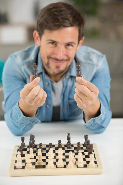 チェスの駒を持った若い男が — ストック写真