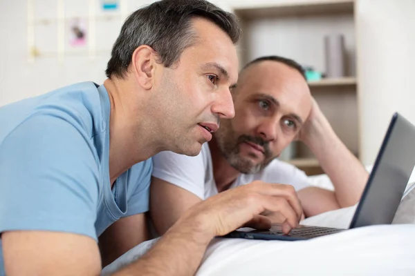 Man Leunend Zijn Vriendje Bed Kijken Naar Een Laptop — Stockfoto