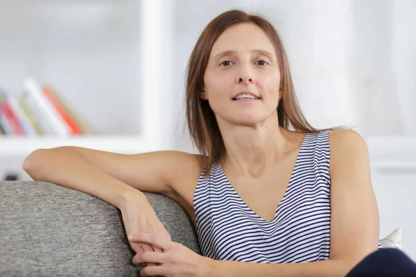 Glücklich Attraktive Junge Erwachsene Frau Sitzt Auf Dem Sofa — Stockfoto