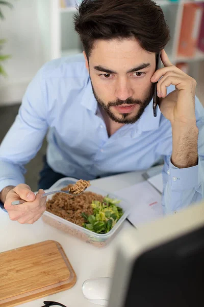 Άντρας Δουλεύει Ενώ Τρώει Μεσημεριανό Στο Γραφείο — Φωτογραφία Αρχείου